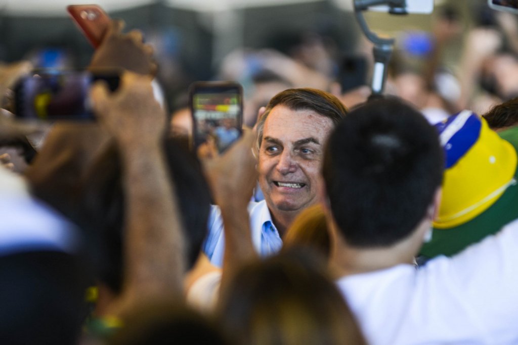 Bolsonaro entra de surpresa em avião, ganha abraços, mas é xingado por opositores